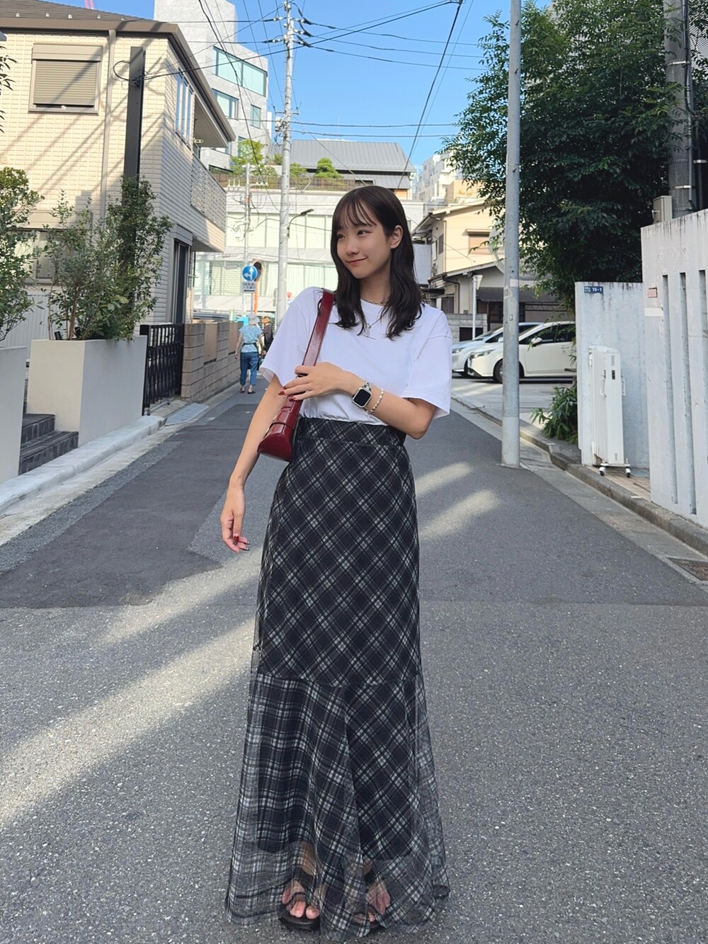 ホワイト系のTシャツ/カットソー、レッド系のショルダーバッグ、ブラック系のスカートを着用したレディースの夏コーディネートの2枚目の写真