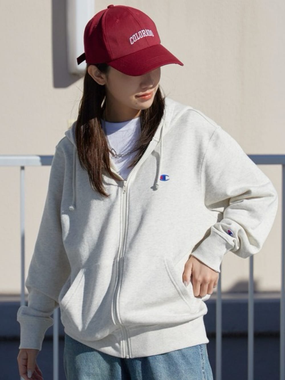 ベージュ系のパーカー、ブルー系のデニムパンツ、ホワイト系のスニーカーを着用したレディースの冬コーディネートの2枚目の写真