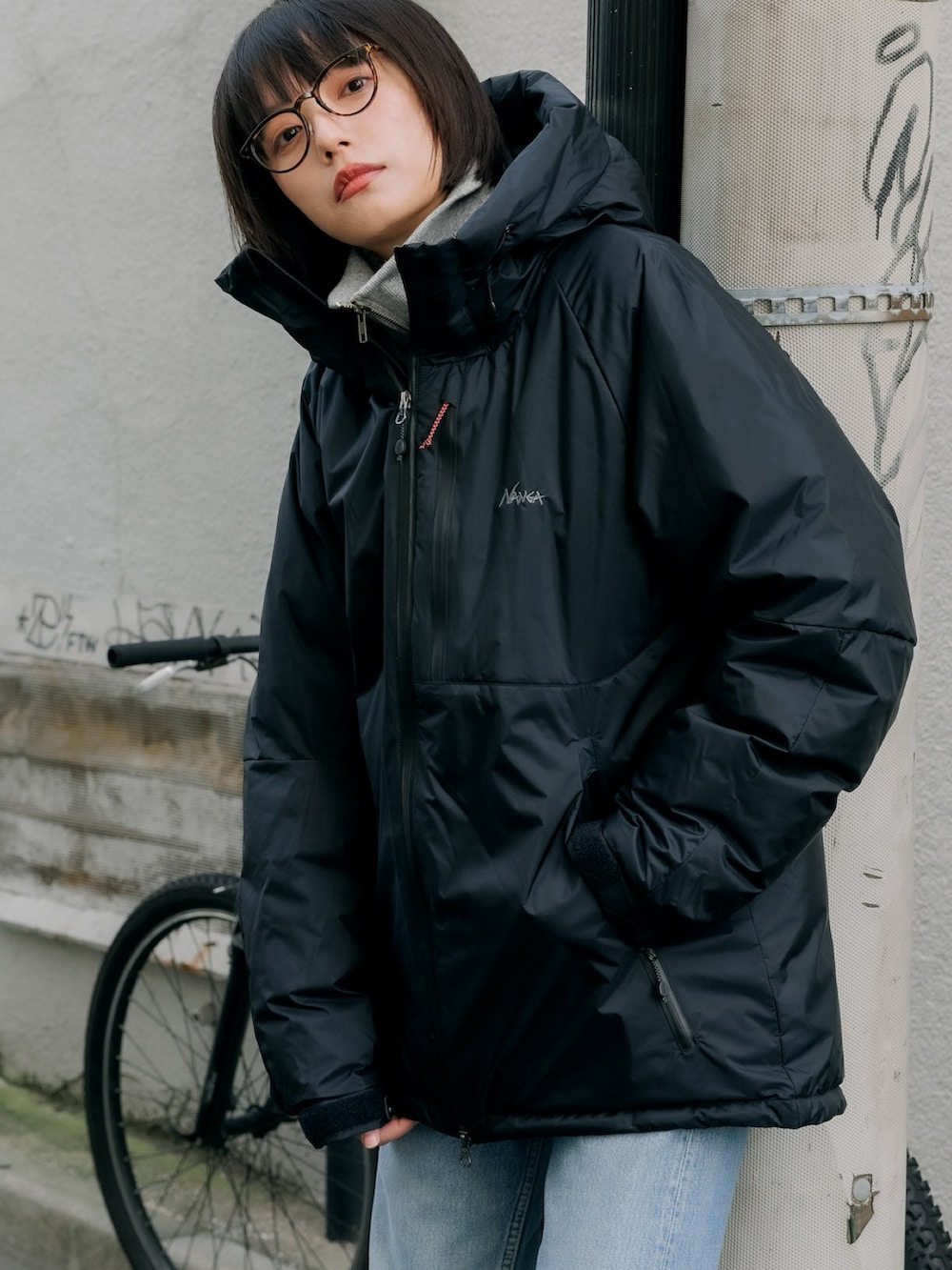 ブラック系のダウンジャケット/コート、ブルー系のデニムパンツ、ブラック系のダウンジャケット/コートを着用したレディースの秋コーディネートの3枚目の写真