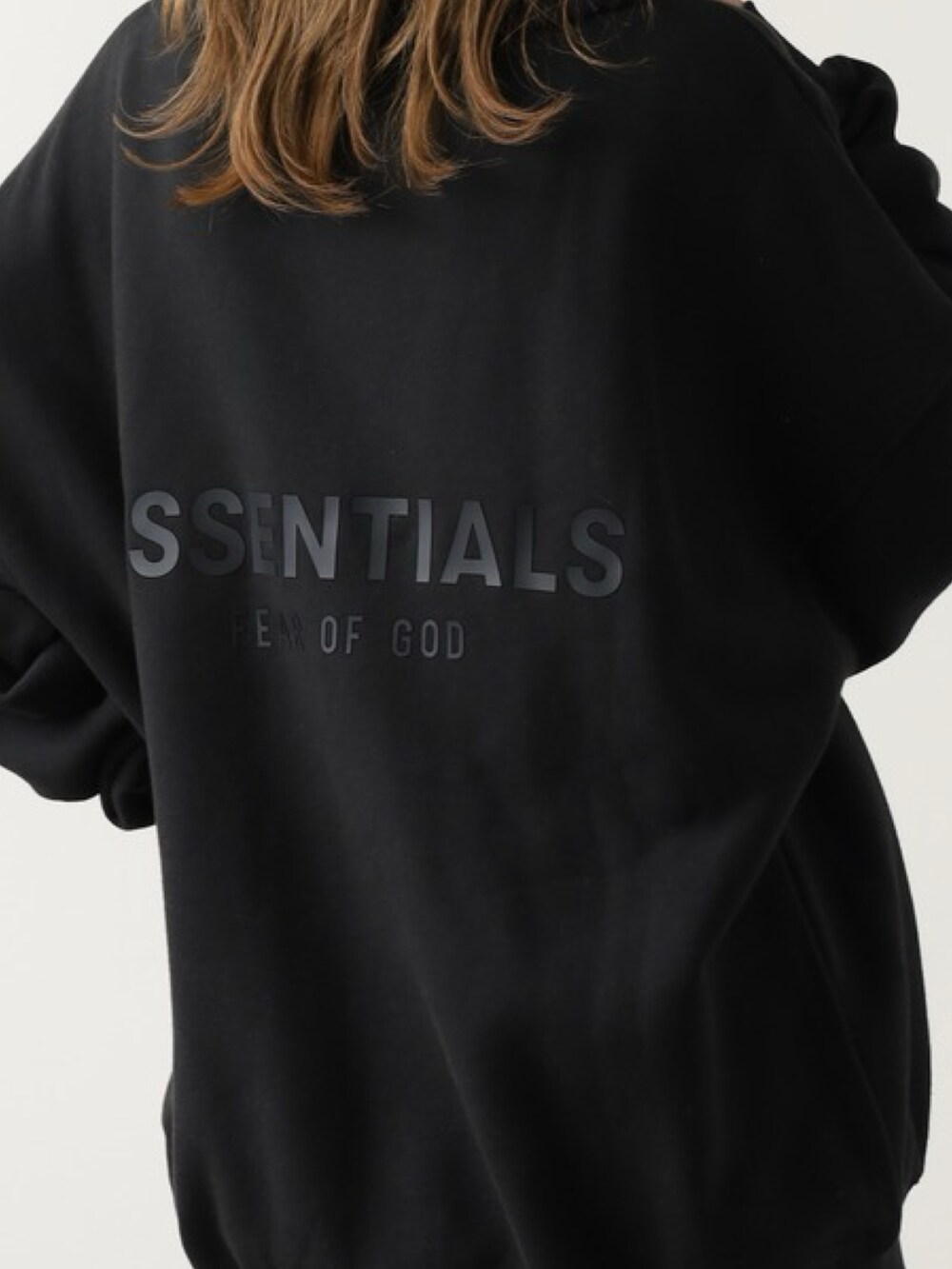 ブラック系のスウェット、ベージュ系のスカート、ホワイト系のスニーカーを着用したレディースの夏コーディネートの3枚目の写真