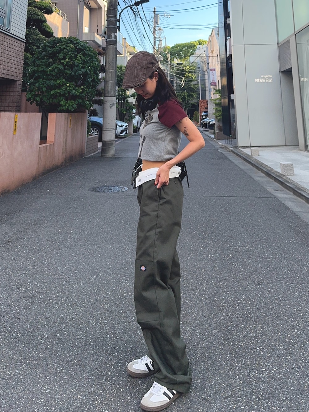 グレー系のTシャツ/カットソー、ホワイト系のスニーカー、ブラック系のショルダーバッグを着用したレディースの夏コーディネートの2枚目の写真