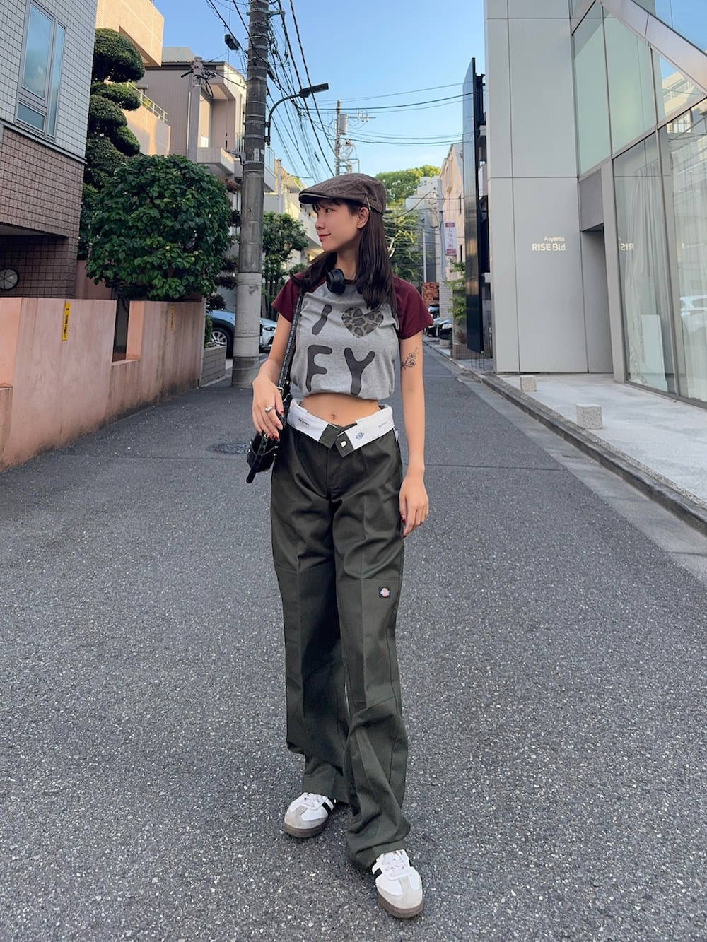 グリーン系のチノパンツ、ホワイト系のスニーカー、グレー系のTシャツ/カットソーを着用したレディースの夏コーディネートの2枚目の写真