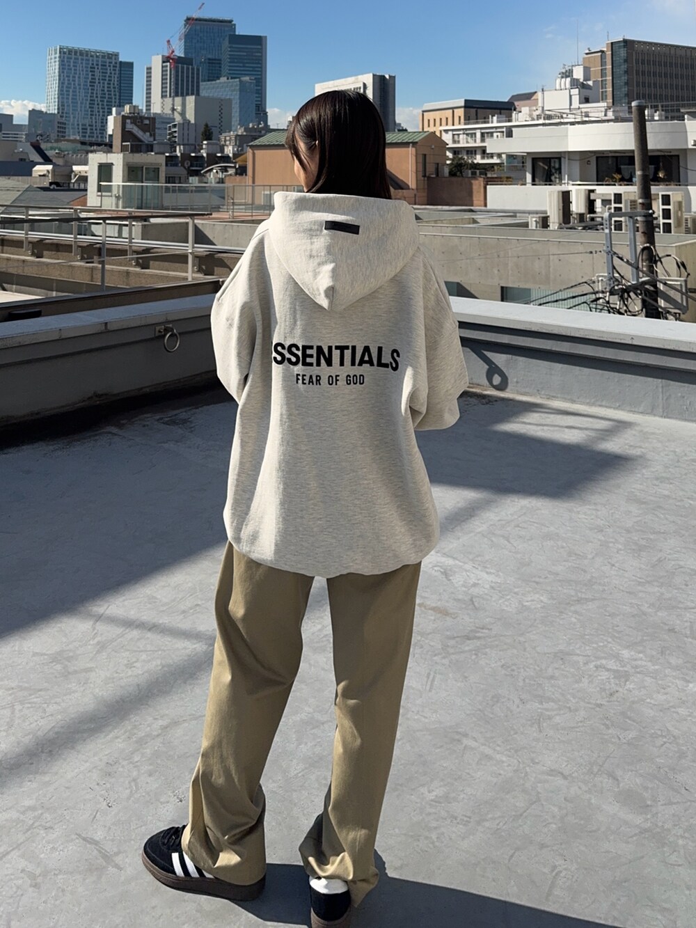 ベージュ系のチノパンツ、グレー系のパーカーを着用したレディースの冬コーディネートの2枚目の写真