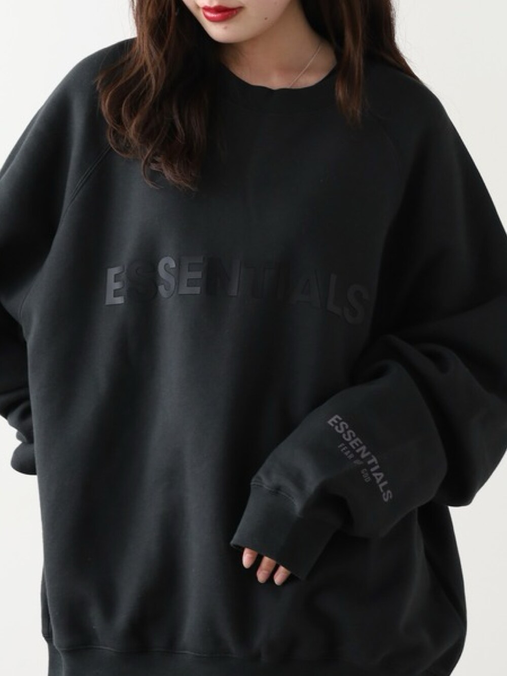 ブラック系のスウェット、ブルー系のデニムパンツ、ピンク系のスニーカーを着用したレディースの秋コーディネートの2枚目の写真