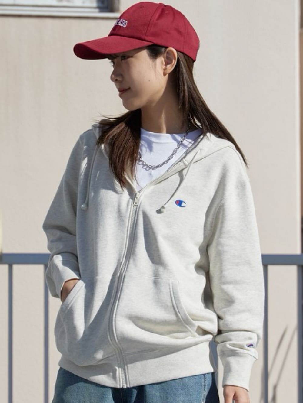 ベージュ系のパーカー、ブルー系のデニムパンツ、ホワイト系のスニーカーを着用したレディースの冬コーディネートの3枚目の写真