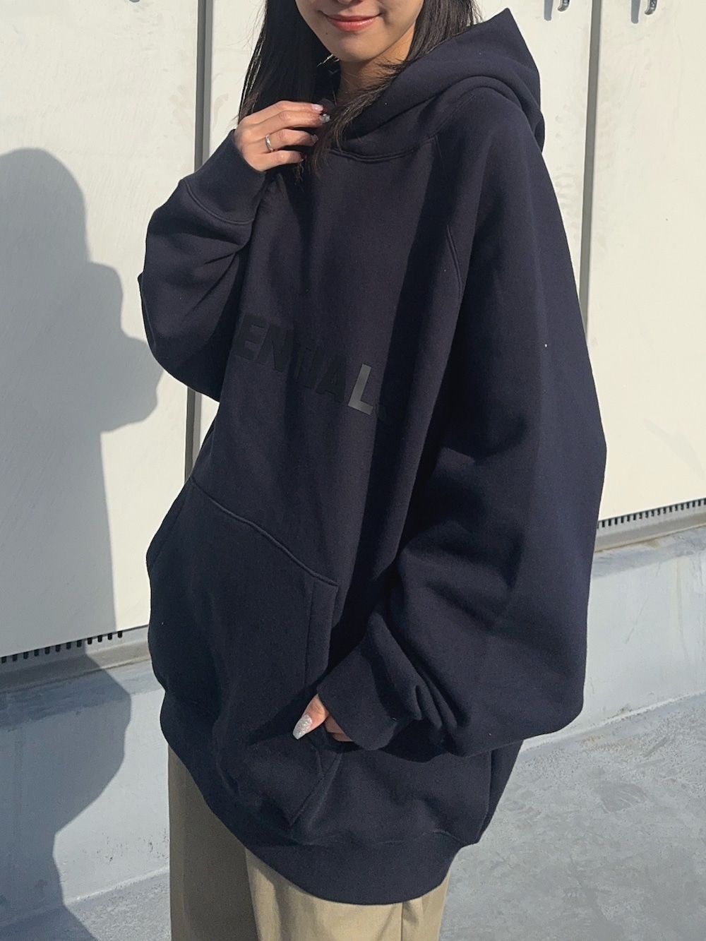 ブルー系のパーカー、グリーン系のチノパンツ、ブラック系のブーツを着用したレディースの冬コーディネートの2枚目の写真