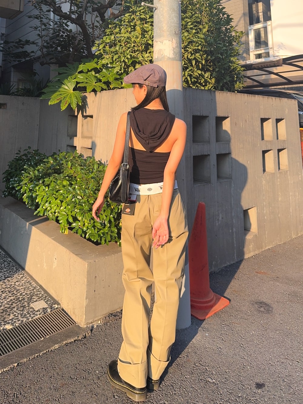 ベージュ系のチノパンツ、ブラック系のタンクトップ、ブラック系のショルダーバッグを着用したレディースの夏コーディネートの2枚目の写真