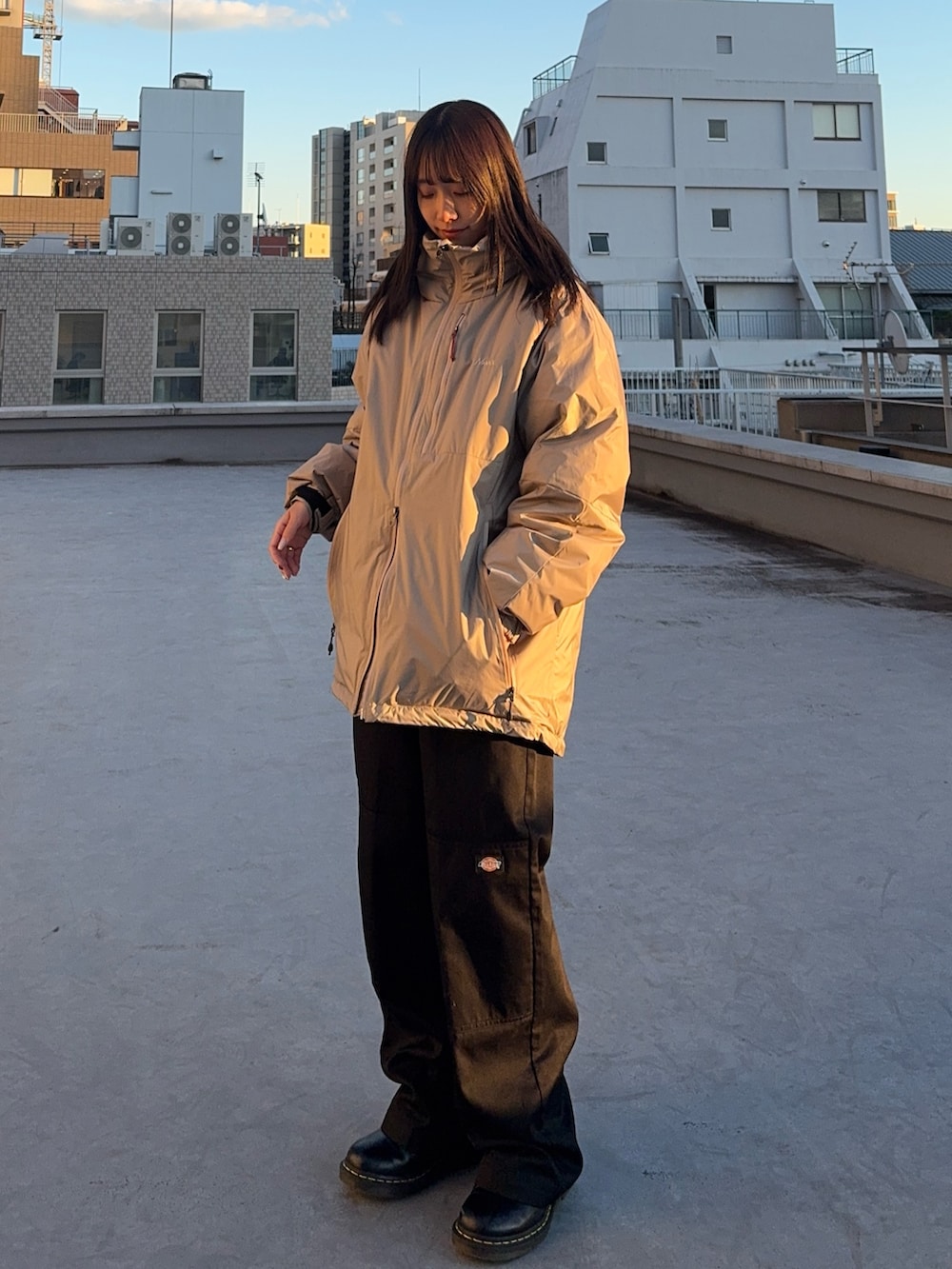 ベージュ系のダウンジャケット/コート、ブラック系のチノパンツ、ブラック系のブーツを着用したレディースの冬コーディネートの2枚目の写真