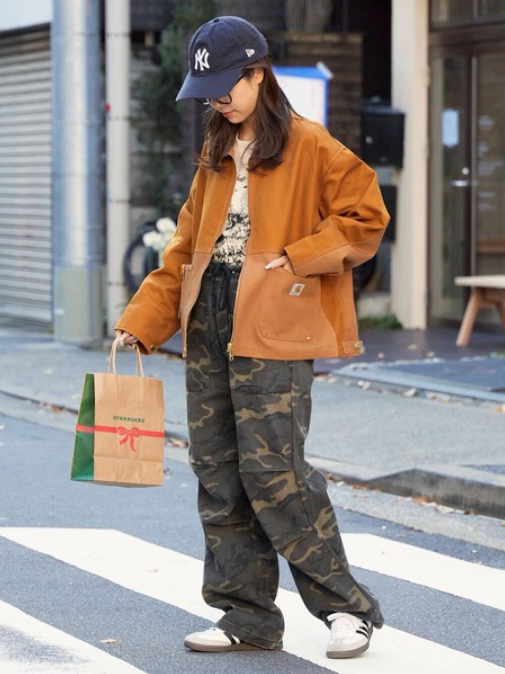 ブラウン系のブルゾン、ホワイト系のTシャツ/カットソーを着用したレディースの冬コーディネートの2枚目の写真