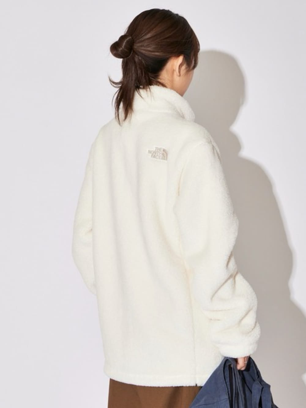 ブラウン系のスラックス、ベージュ系のブルゾンを着用したレディースの秋コーディネートの4枚目の写真