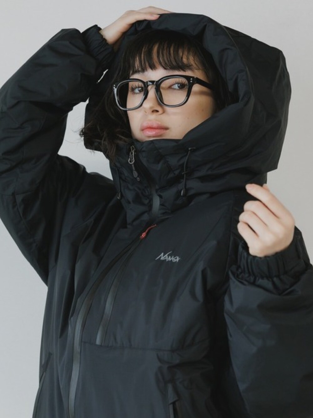 ブラック系のスラックス、ブラック系のダウンジャケット/コート、ブラック系のメガネを着用したレディースの秋コーディネートの3枚目の写真