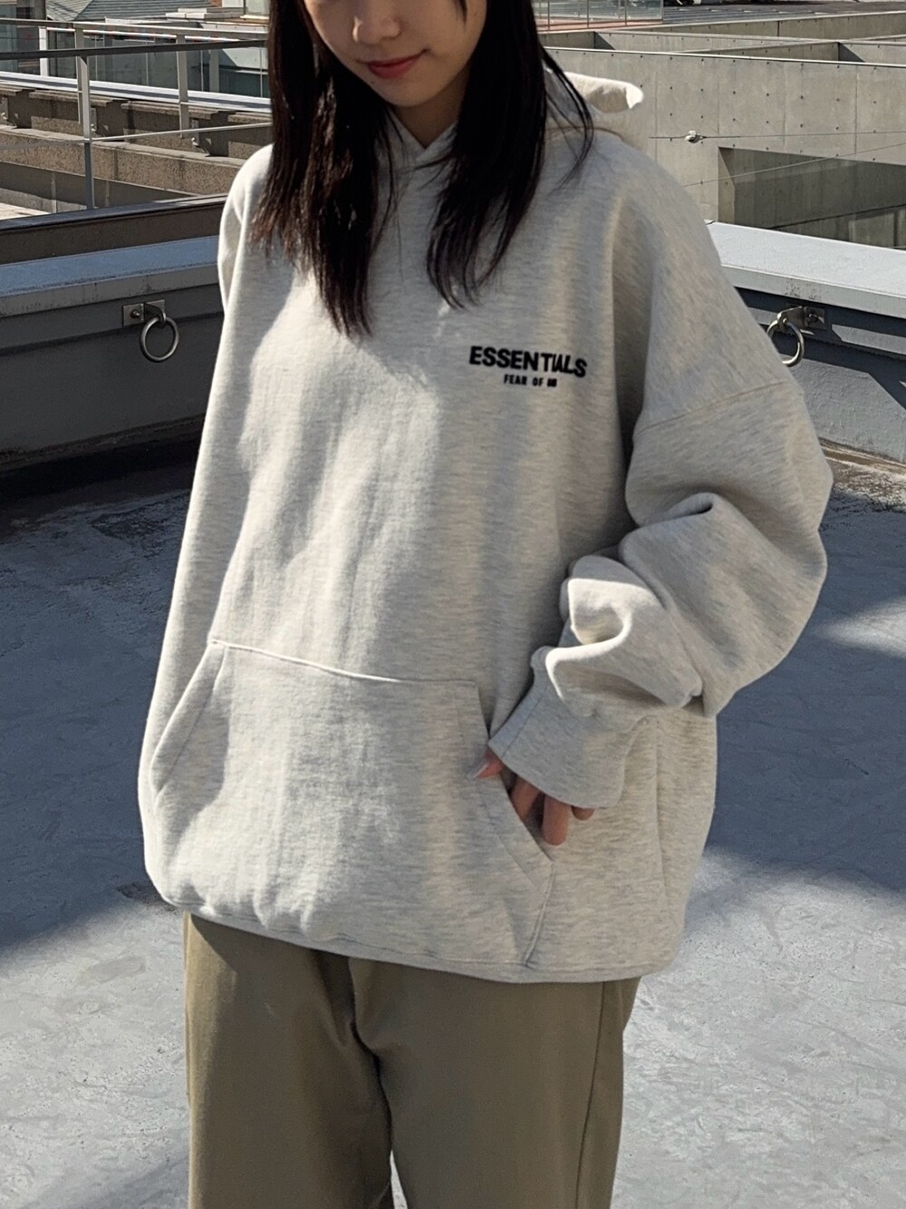 ベージュ系のチノパンツ、グレー系のパーカーを着用したレディースの冬コーディネートの3枚目の写真