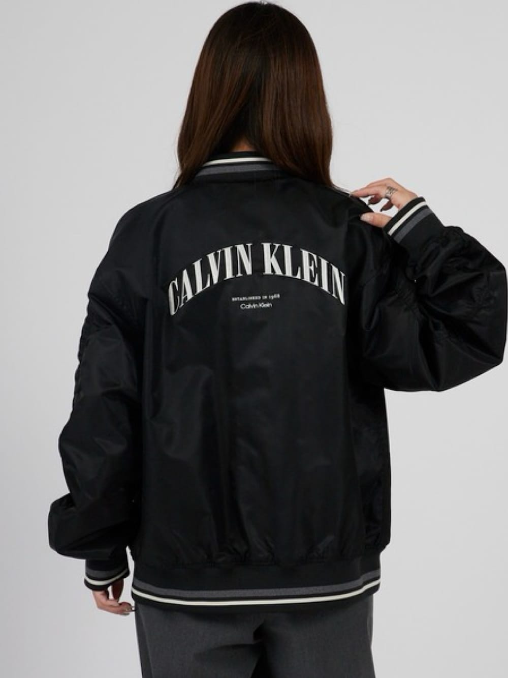 ブラック系のブルゾン、ホワイト系のTシャツ/カットソーを着用したレディースの春コーディネートの2枚目の写真