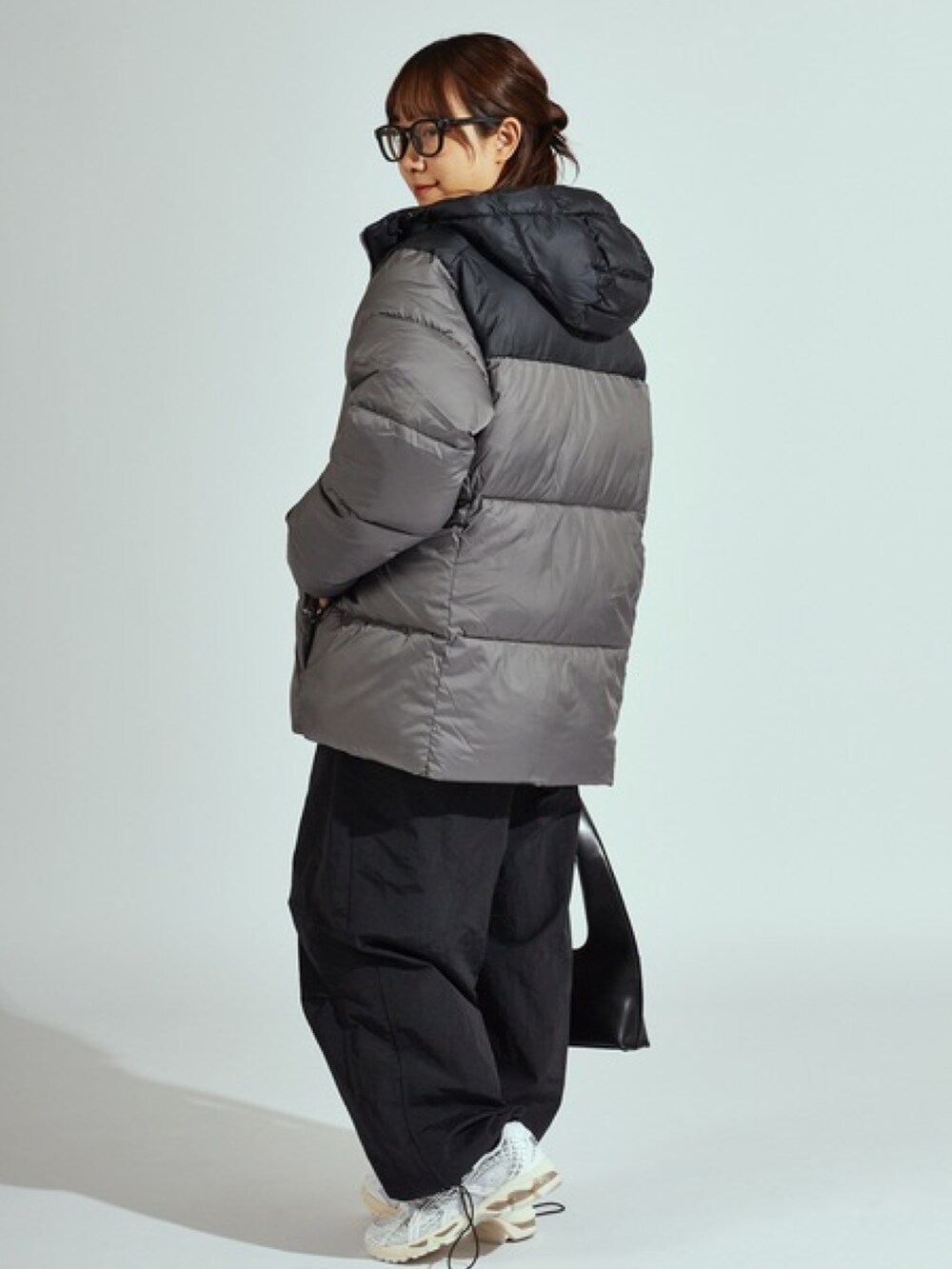 グレー系のダウンジャケット/コート、ホワイト系のスウェットを着用したレディースの秋コーディネートの2枚目の写真