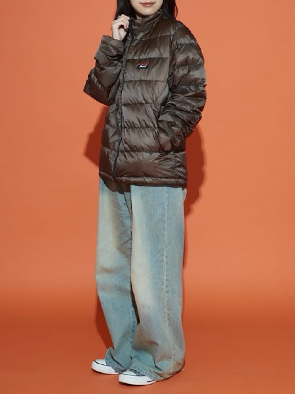 ブラウン系のダウンジャケット/コート、ホワイト系のスウェットを着用したレディースの冬コーディネートの2枚目の写真