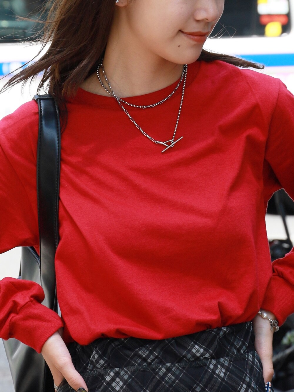 レッド系のTシャツ/カットソー、ブラック系のスカート、ブラック系のブーツを着用したレディースの秋コーディネートの2枚目の写真