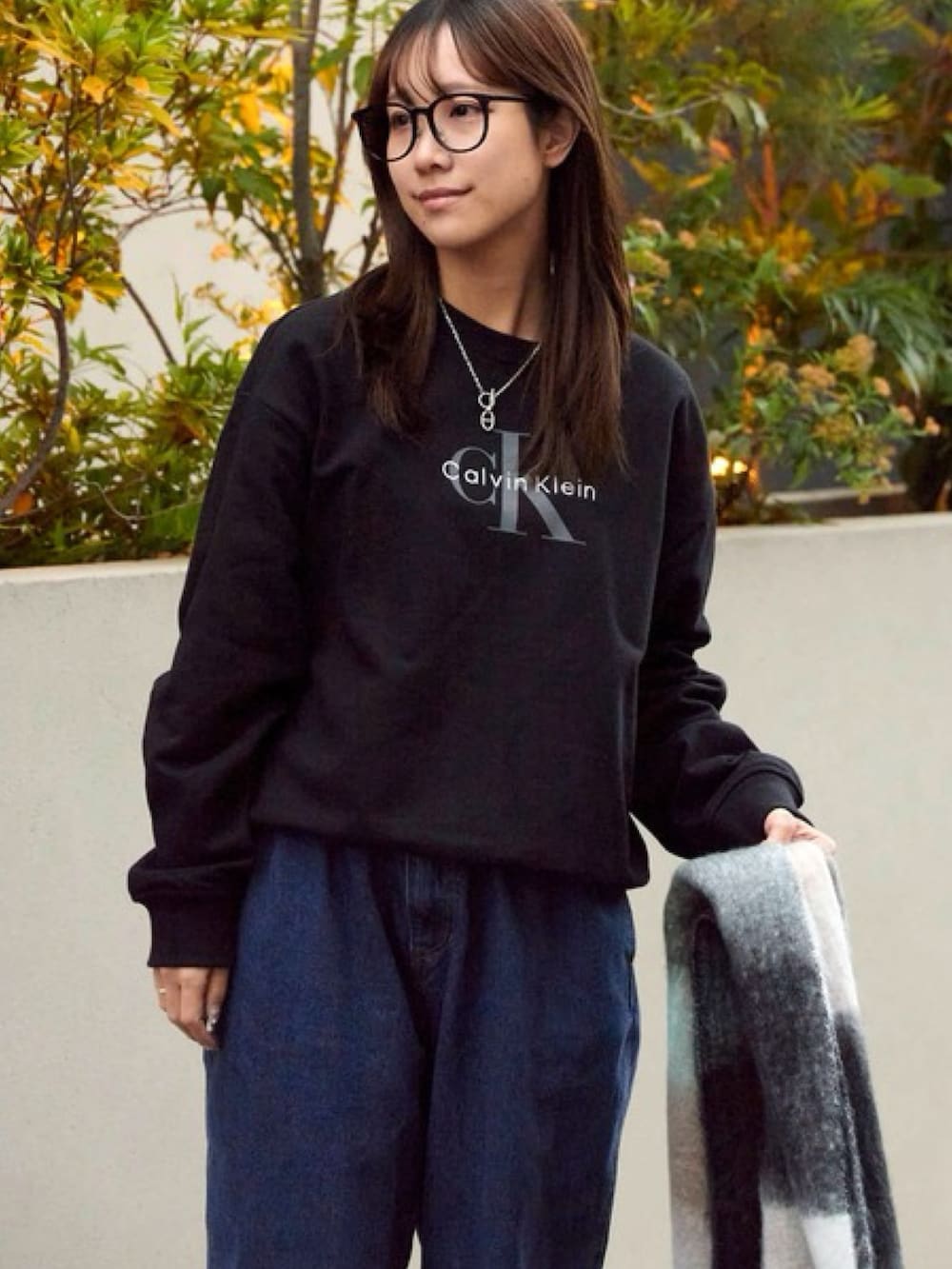 ブラック系のスウェット、ブラック系のメガネを着用したレディースの秋コーディネートの2枚目の写真