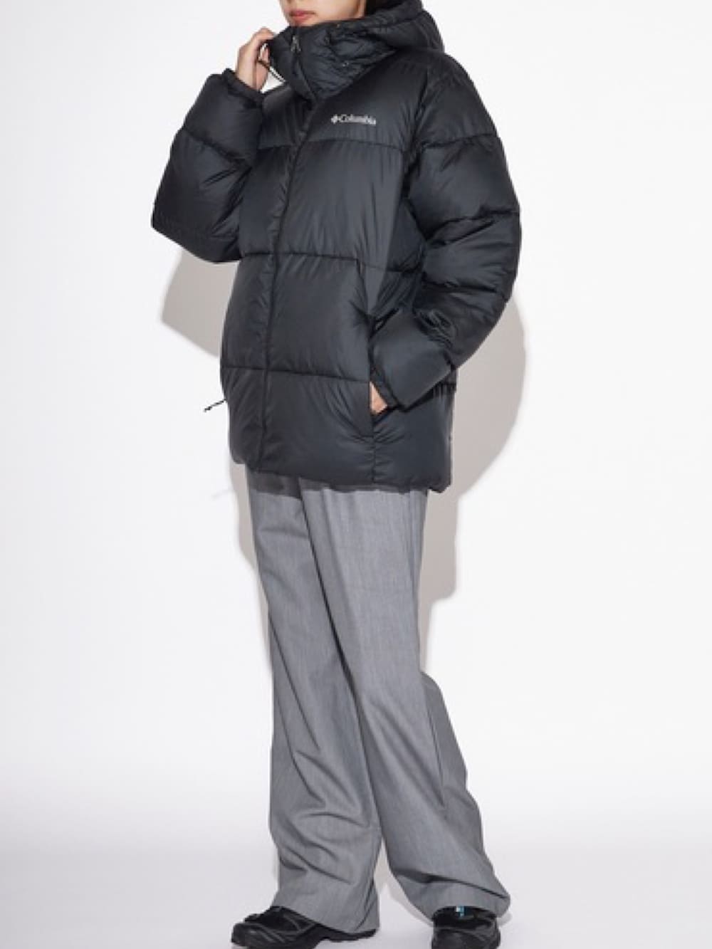 ブラック系のダウンジャケット/コート、グレー系のスラックス、ブラック系のメガネを着用したレディースの秋コーディネートの3枚目の写真