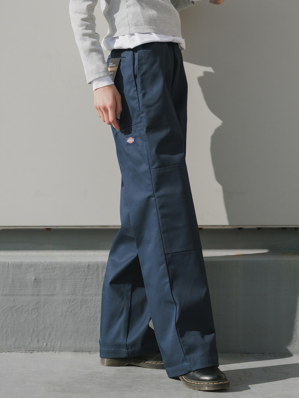 ブルー系のチノパンツ、ホワイト系のTシャツ/カットソー、ブラック系のブーツを着用したレディースの冬コーディネートの2枚目の写真