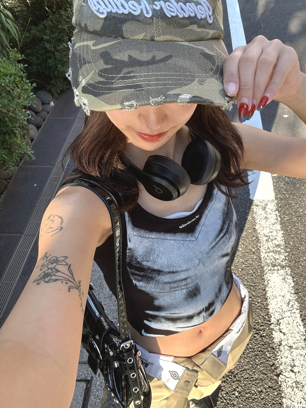 ベージュ系のチノパンツ、ブラック系のショルダーバッグ、ブラック系のタンクトップを着用したレディースの夏コーディネートの2枚目の写真