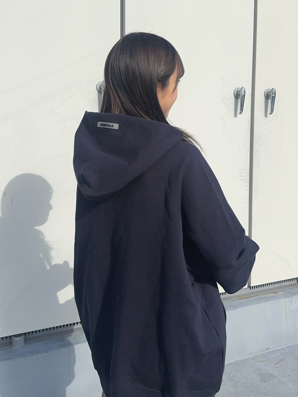 ブルー系のパーカー、グリーン系のチノパンツ、ブラック系のブーツを着用したレディースの冬コーディネートの3枚目の写真