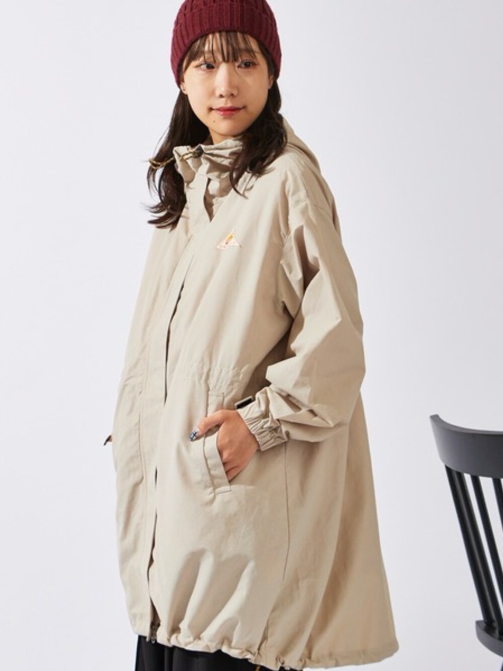 ベージュ系のマウンテンパーカー、ブラック系のスラックス、ブラック系のスニーカーを着用したレディースの秋コーディネートの3枚目の写真