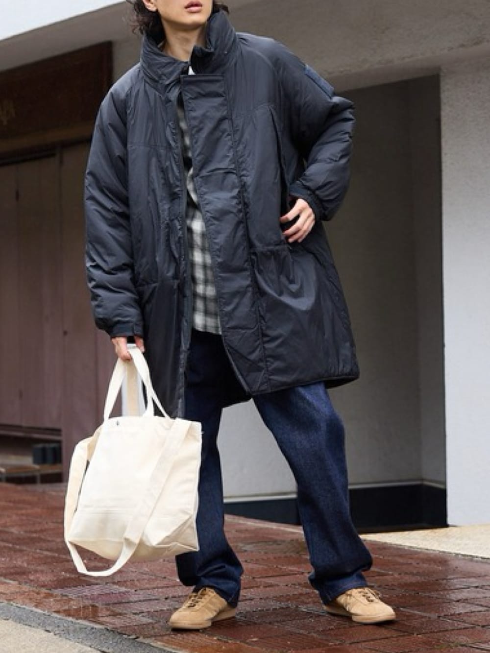 ブラック系のダウンジャケット/コート、ブルー系のデニムパンツを着用したレディースの秋コーディネートの2枚目の写真