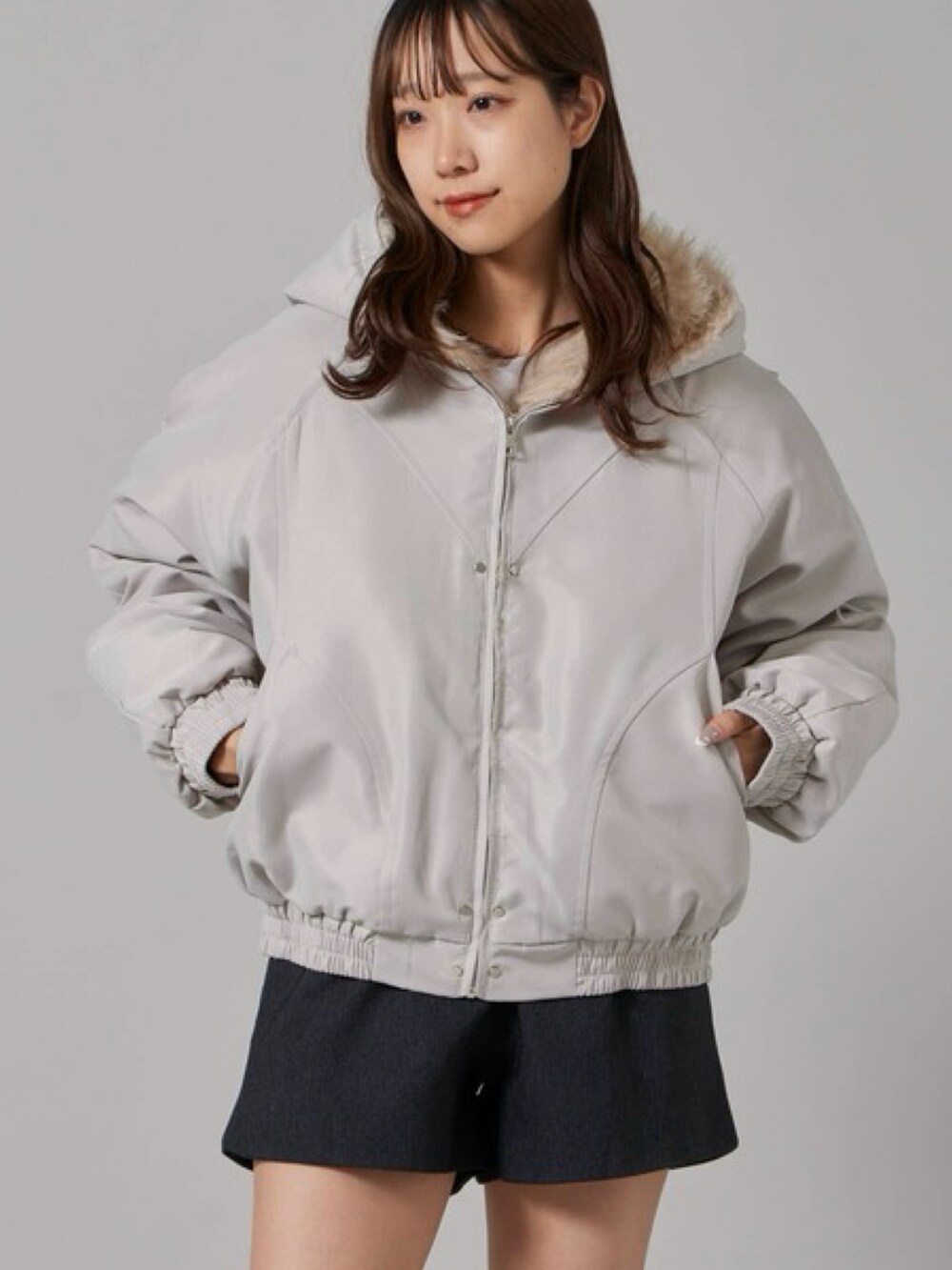 グレー系のダウンジャケット/コート、グレー系のその他パンツ、ブラック系のブーツを着用したレディースの冬コーディネートの2枚目の写真