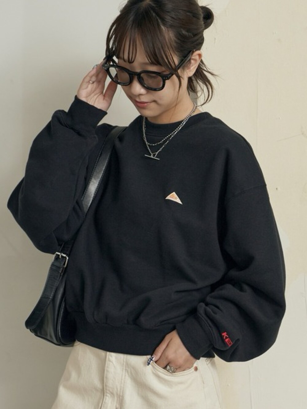 ブラック系のTシャツ/カットソー、ベージュ系のスラックス、ホワイト系のスニーカーを着用したレディースの秋コーディネートの2枚目の写真