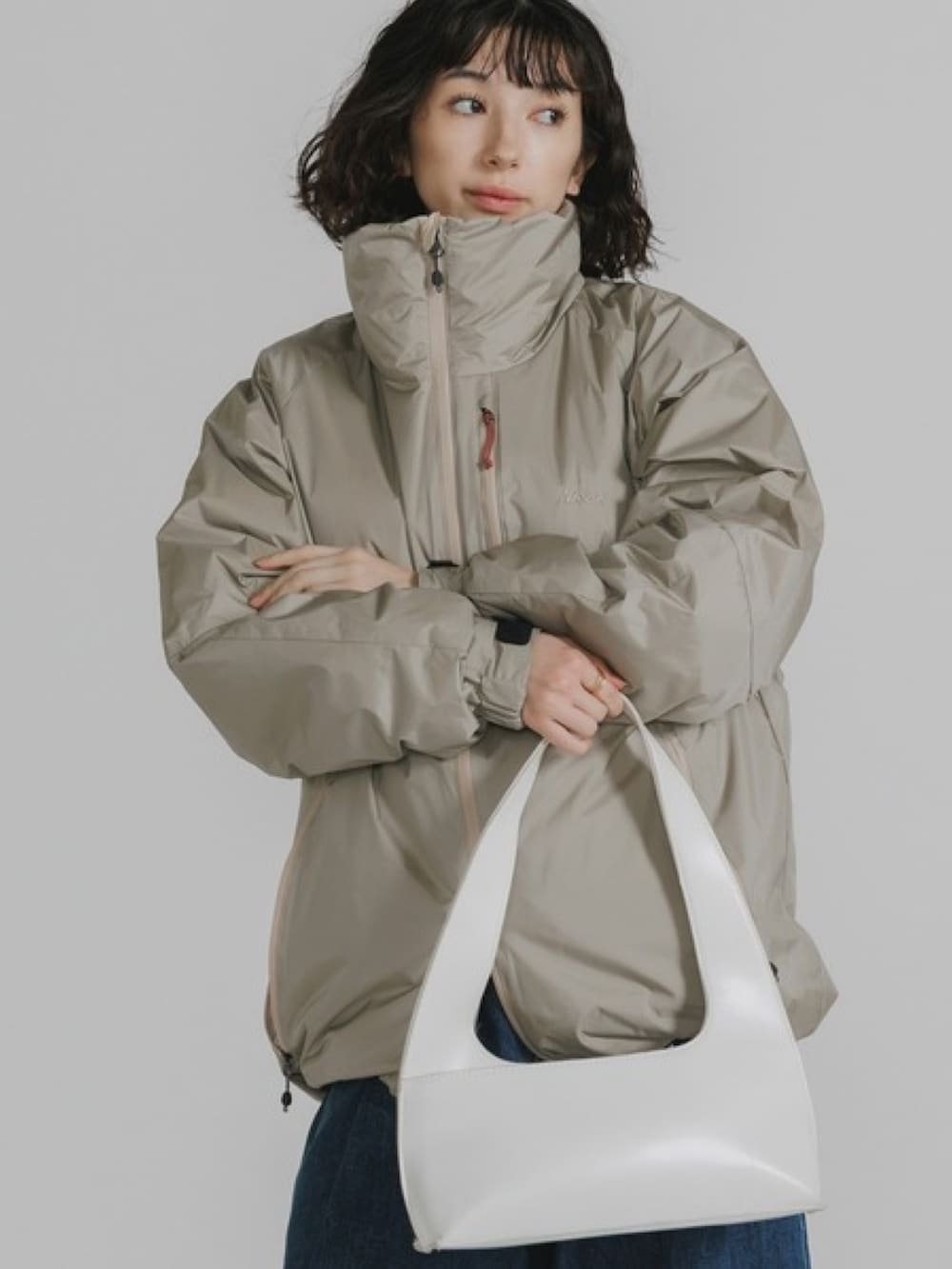 ベージュ系のダウンジャケット/コート、ブルー系のデニムパンツを着用したレディースの秋コーディネートの3枚目の写真