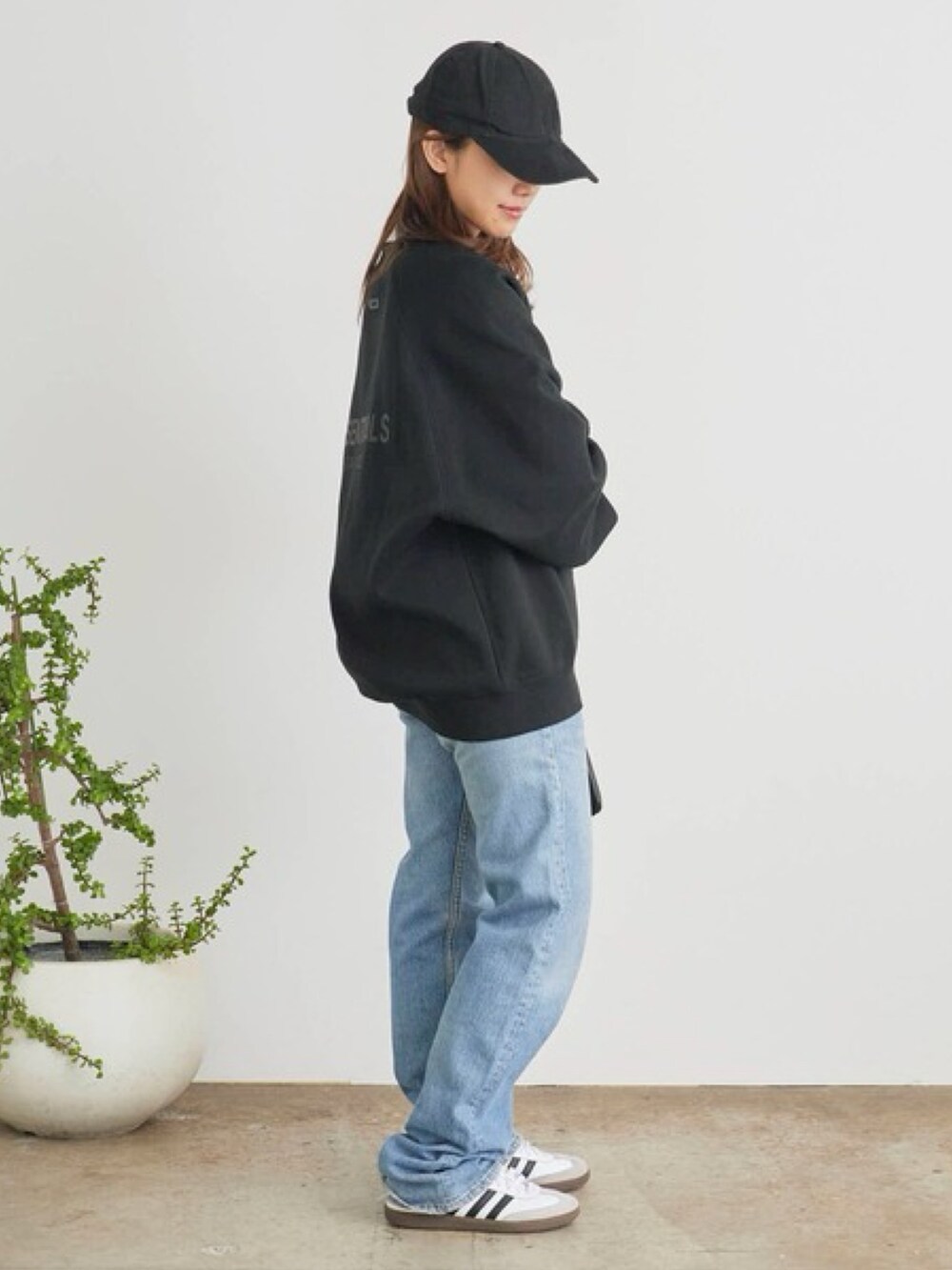 ブラック系のスウェット、ブルー系のデニムパンツを着用したレディースの秋コーディネートの2枚目の写真