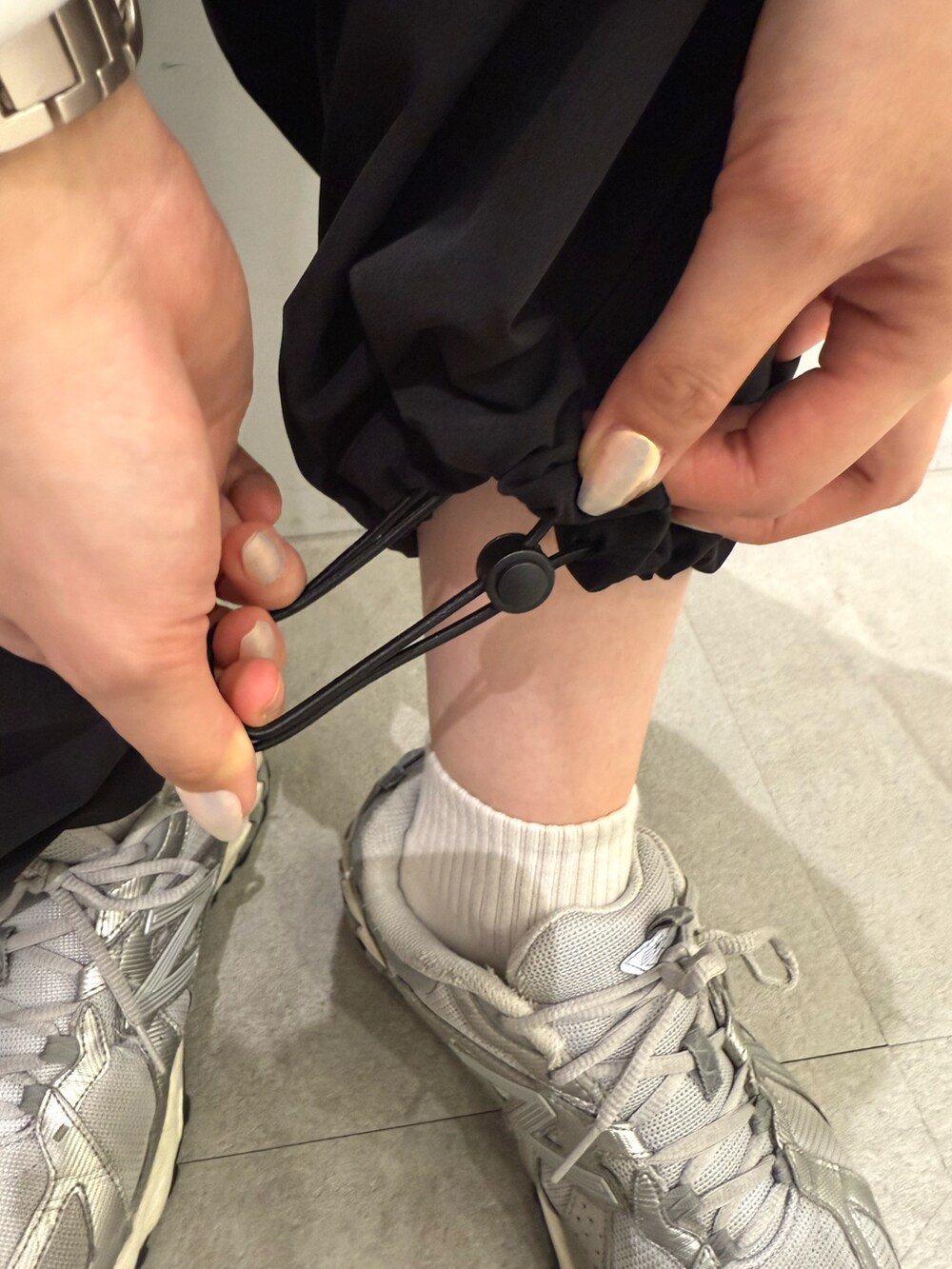 ブラック系のカーゴパンツ、ホワイト系のパーカー、ブラック系のショルダーバッグを着用したレディースの春コーディネートの4枚目の写真