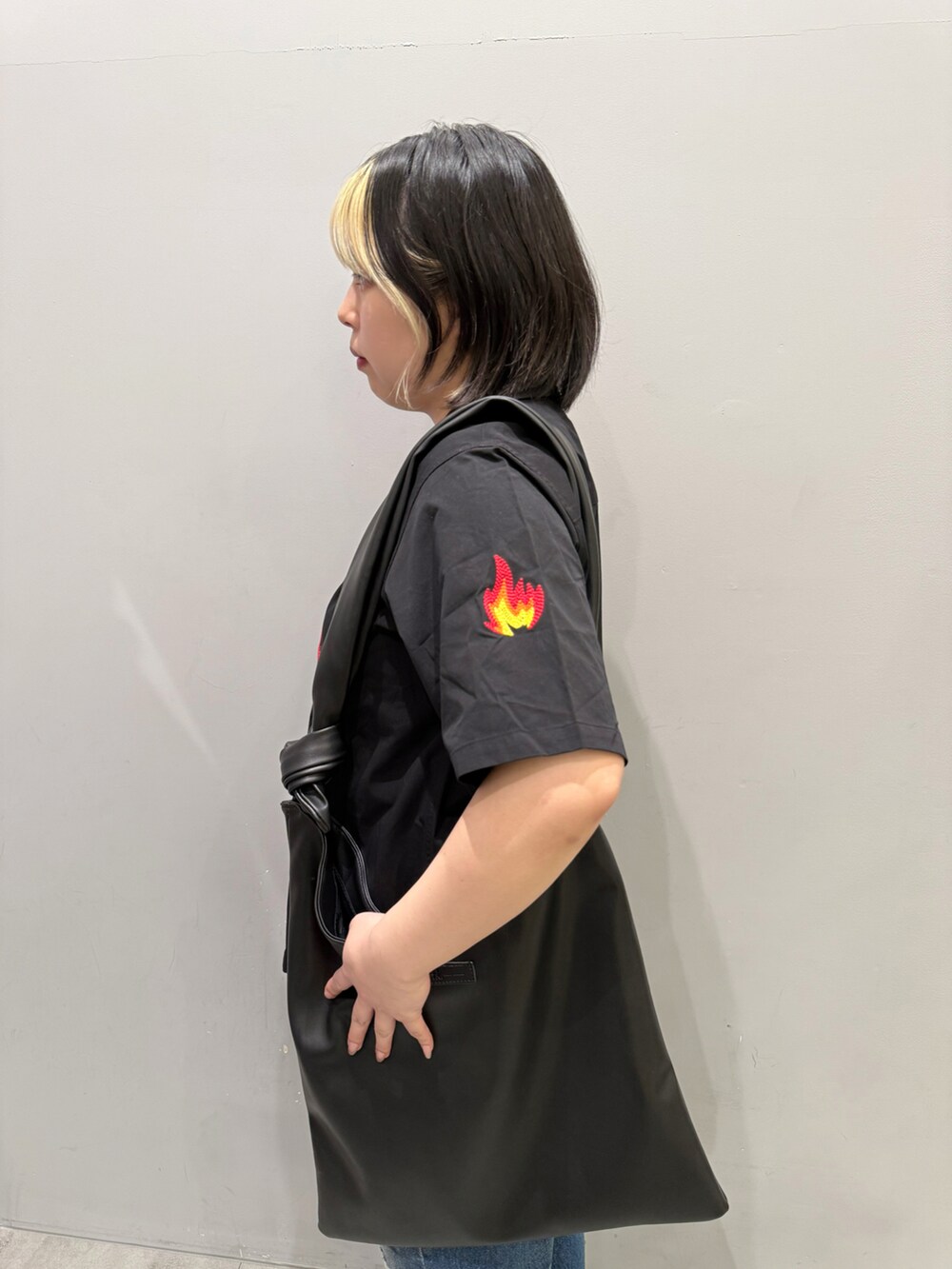 ブルー系のデニムパンツ、ブラック系のシャツ/ブラウス、ブラック系のその他シューズを着用したレディースの春コーディネートの3枚目の写真