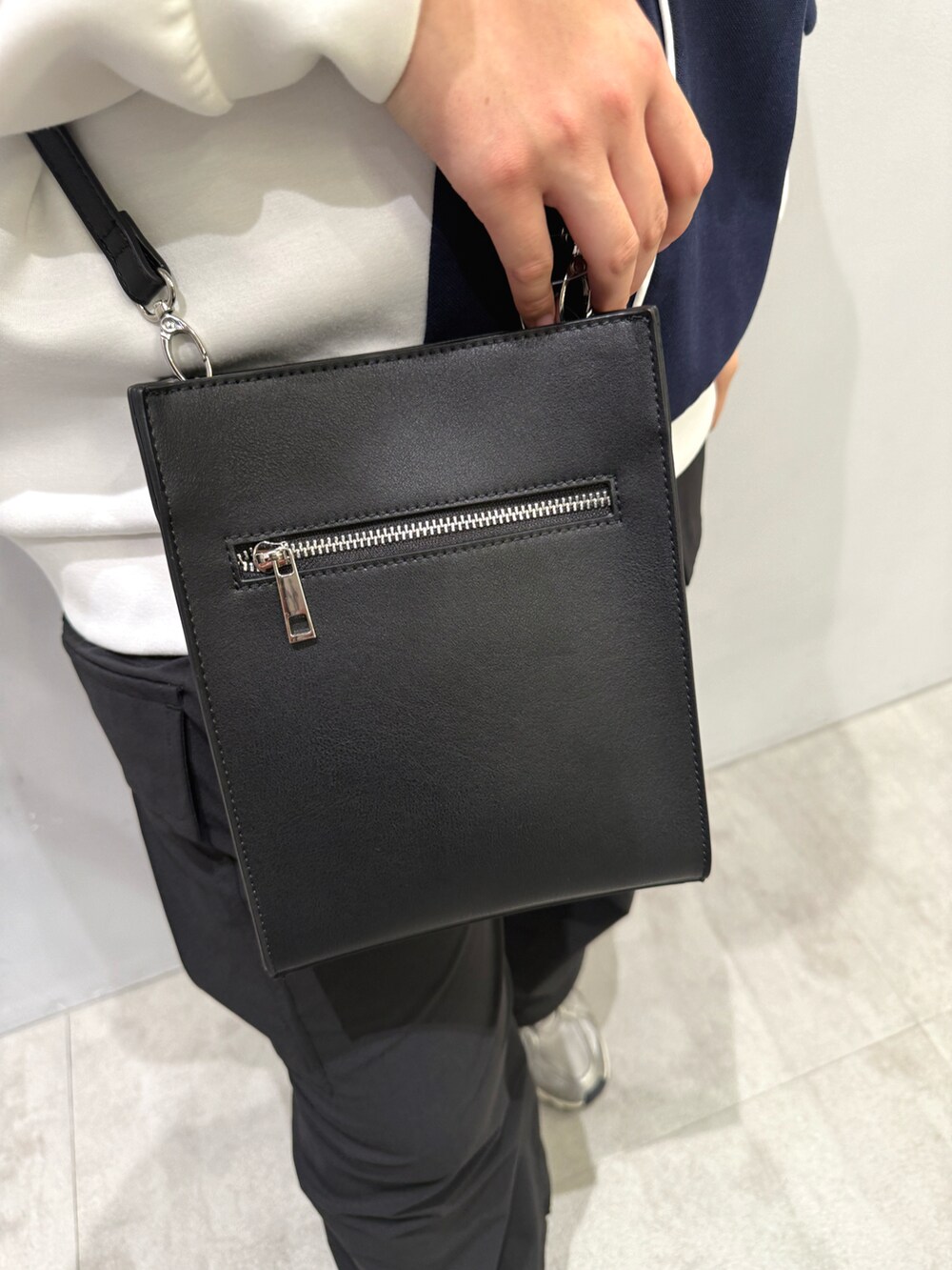 ブラック系のカーゴパンツ、ホワイト系のパーカー、ブラック系のショルダーバッグを着用したレディースの春コーディネートの5枚目の写真