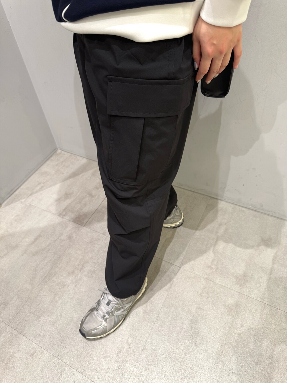 ブラック系のカーゴパンツ、ホワイト系のパーカー、ブラック系のショルダーバッグを着用したレディースの春コーディネートの3枚目の写真