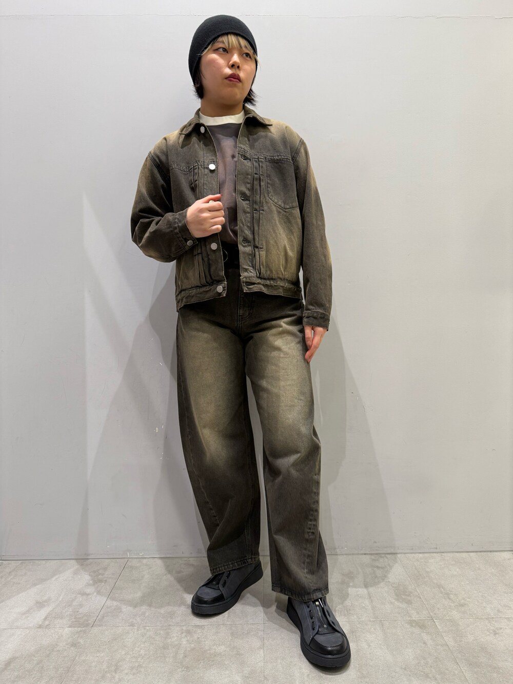 ブルー系のデニムパンツ、グレー系のその他シューズ、ブラウン系のTシャツ/カットソーを着用したレディースの春コーディネートの3枚目の写真