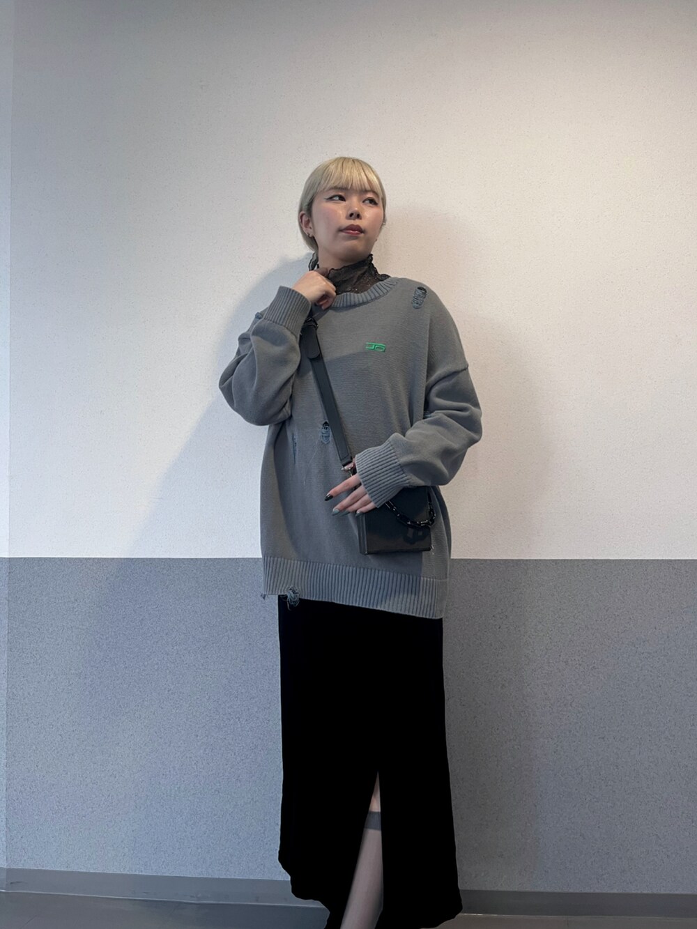 グレー系のニット/セーター、ブラック系のワンピース、ブラック系のショルダーバッグを着用したレディースの夏コーディネートの2枚目の写真