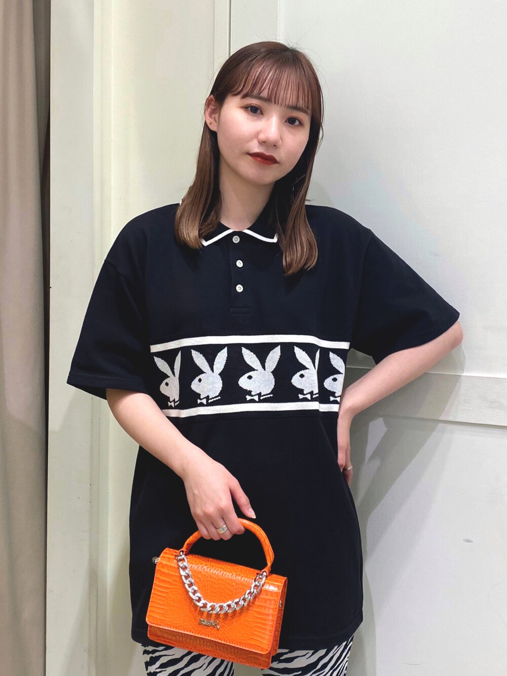 オレンジ系のショルダーバッグ、ホワイト系のその他パンツを着用したレディースの春コーディネートの2枚目の写真