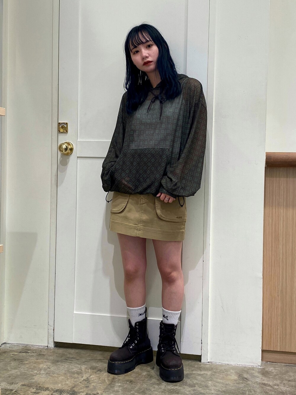 ホワイト系のキャミソール、グリーン系のパーカー、ベージュ系のスカートを着用したレディースの夏コーディネートの2枚目の写真