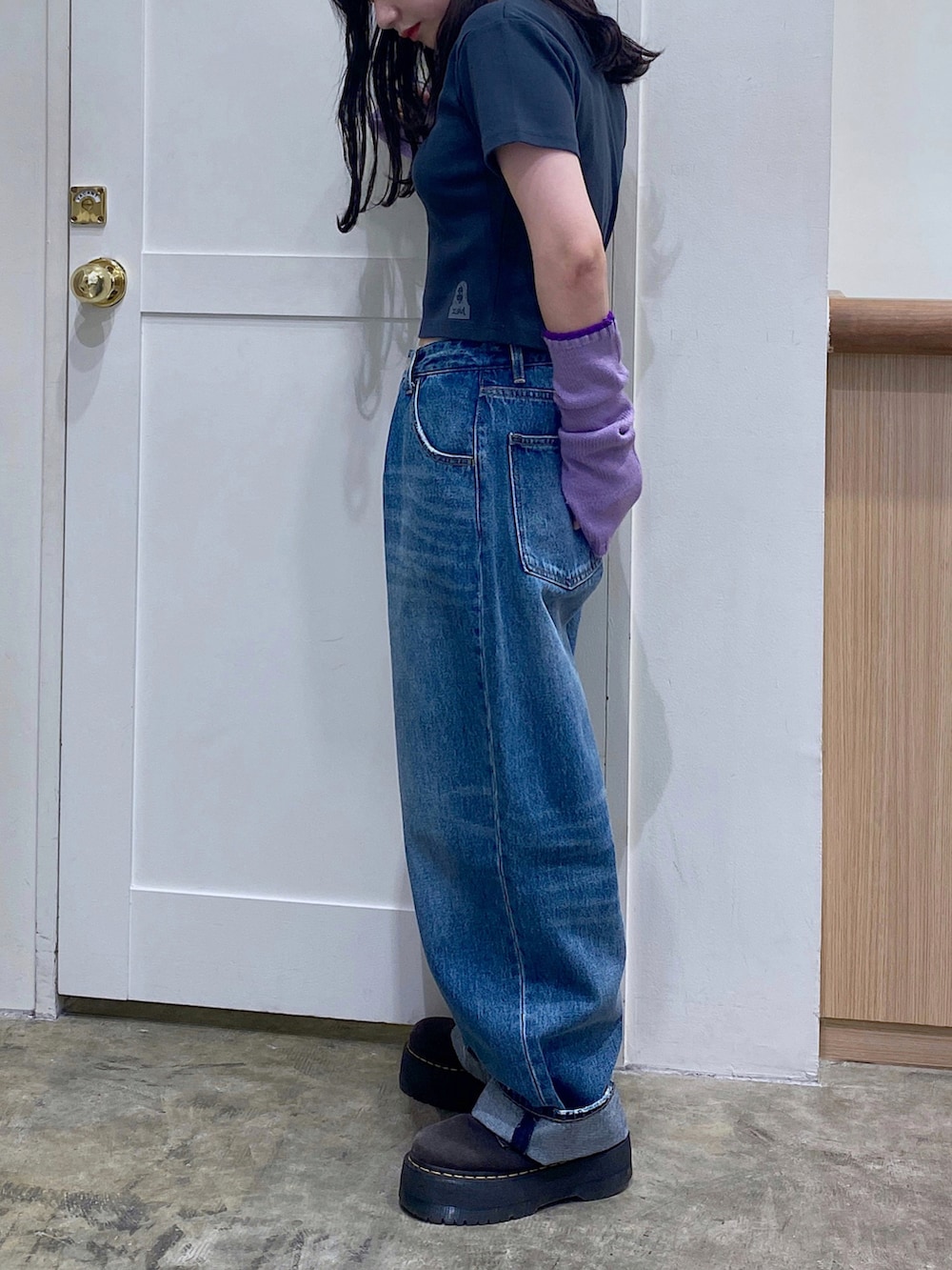 グレー系のTシャツ/カットソー、ブルー系のデニムパンツ、パープル系のアームカバーを着用したレディースの秋コーディネートの2枚目の写真