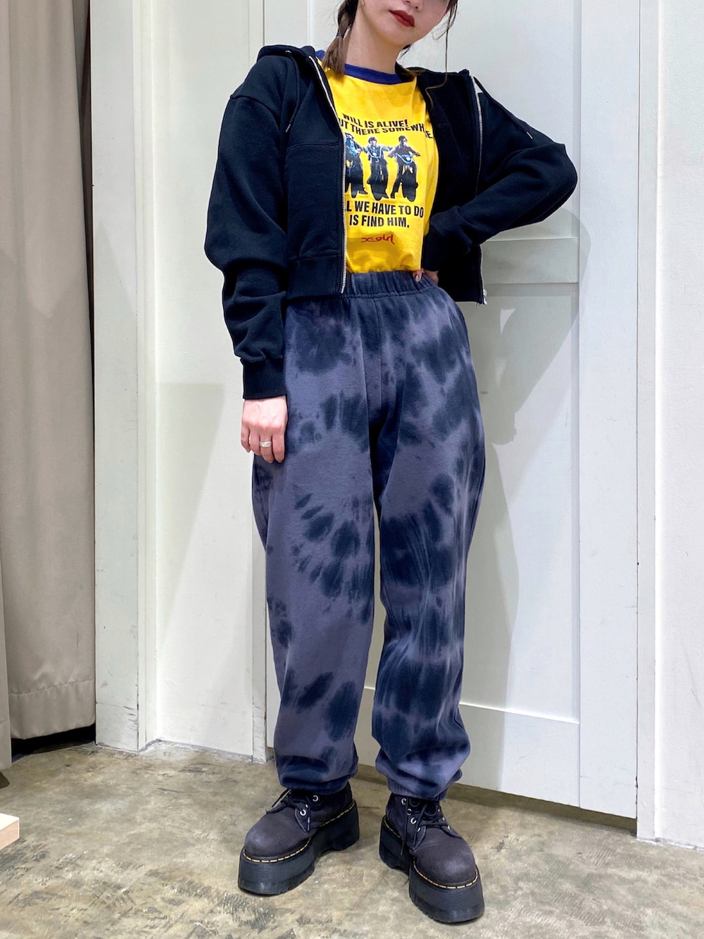 ブラック系のパーカー、イエロー系のTシャツ/カットソー、ブラック系のスウェットパンツを着用したレディースの冬コーディネートの2枚目の写真