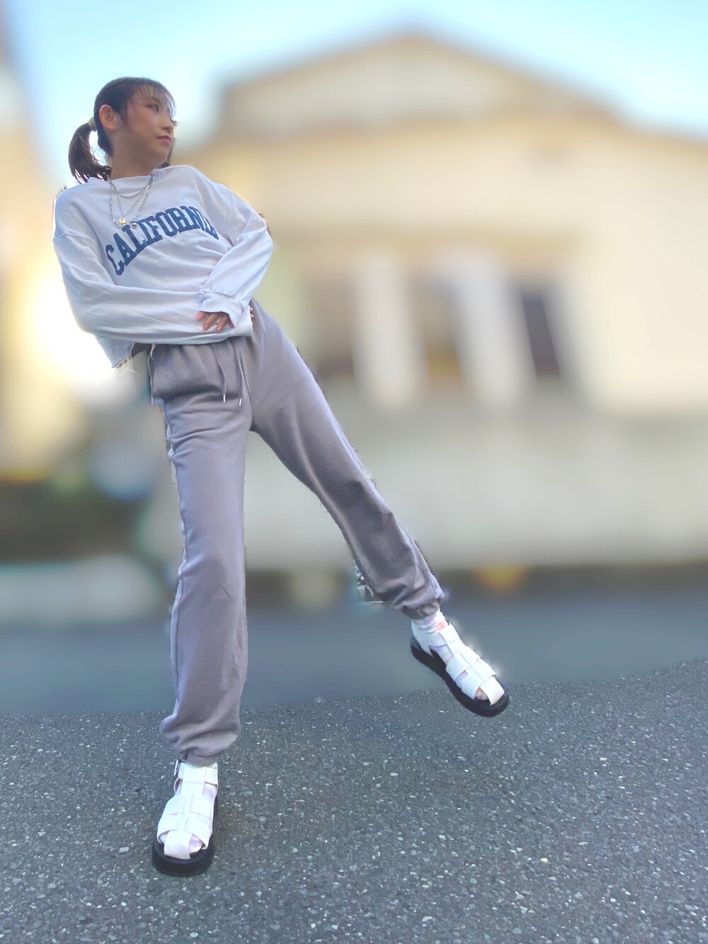 ホワイト系のスウェット、グレー系のスウェットパンツ、ホワイト系のサンダルを着用したレディースの春コーディネートの2枚目の写真