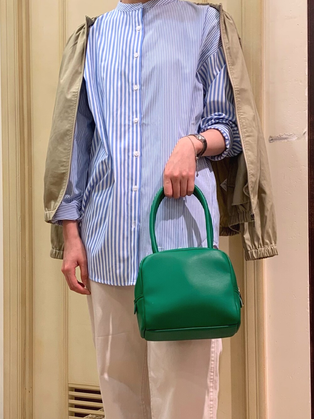 ベージュ系のブルゾン、ブルー系のシャツ/ブラウス、グリーン系のボストンバッグを着用したレディースの春コーディネートの2枚目の写真