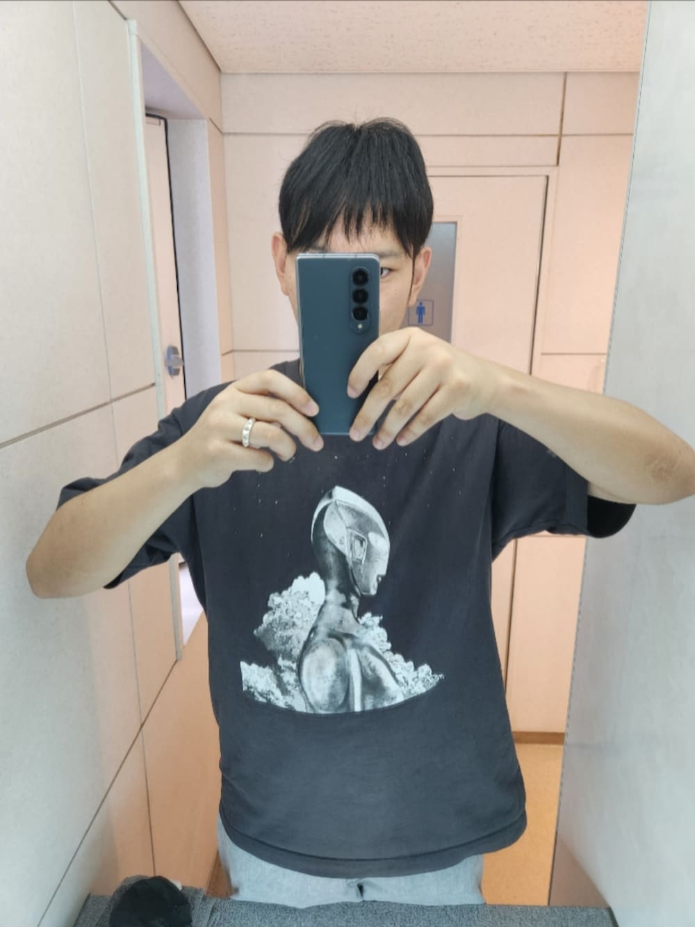 グレー系のTシャツ/カットソー、グレー系のデニムパンツ、ブラック系のスニーカーを着用したメンズの秋コーディネートの2枚目の写真