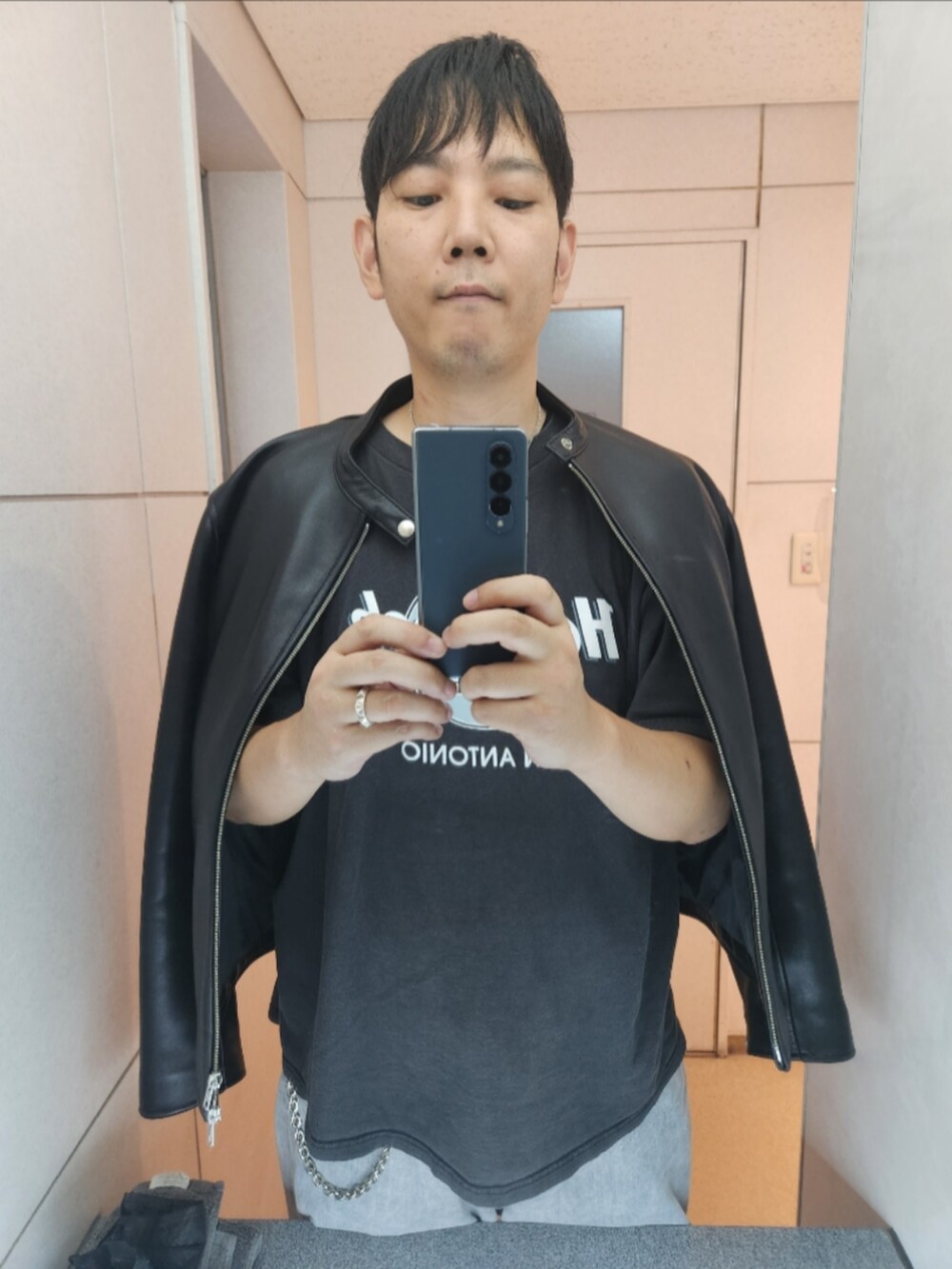 ブラック系のライダースジャケット、グレー系のTシャツ/カットソー、グレー系のデニムパンツを着用したメンズの秋コーディネートの3枚目の写真