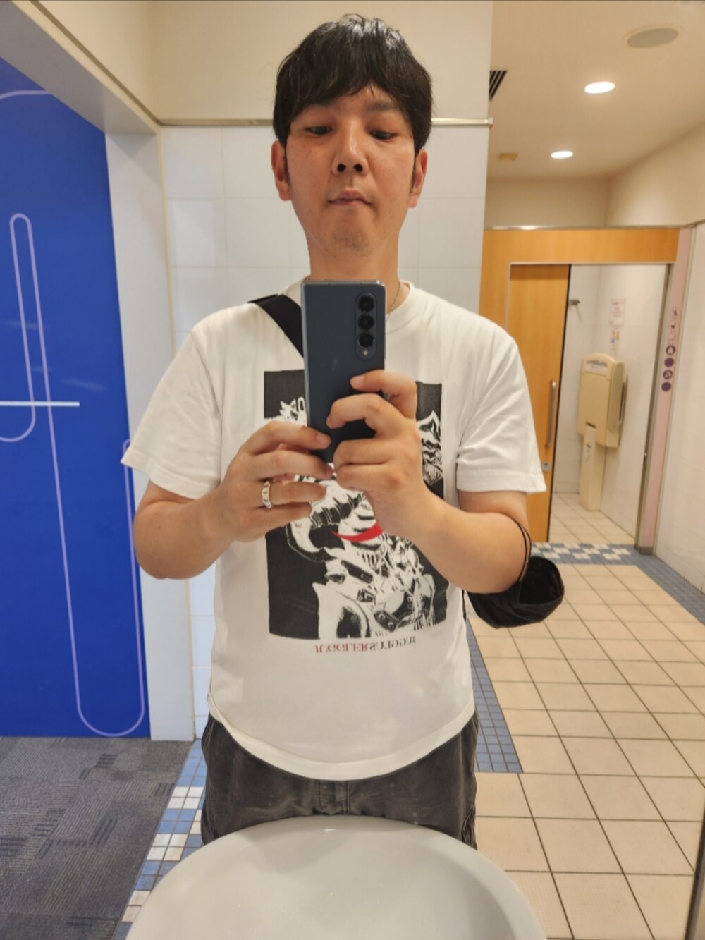 ホワイト系のTシャツ/カットソー、グレー系のカーゴパンツ、ブラック系のスニーカーを着用したメンズの秋コーディネートの3枚目の写真