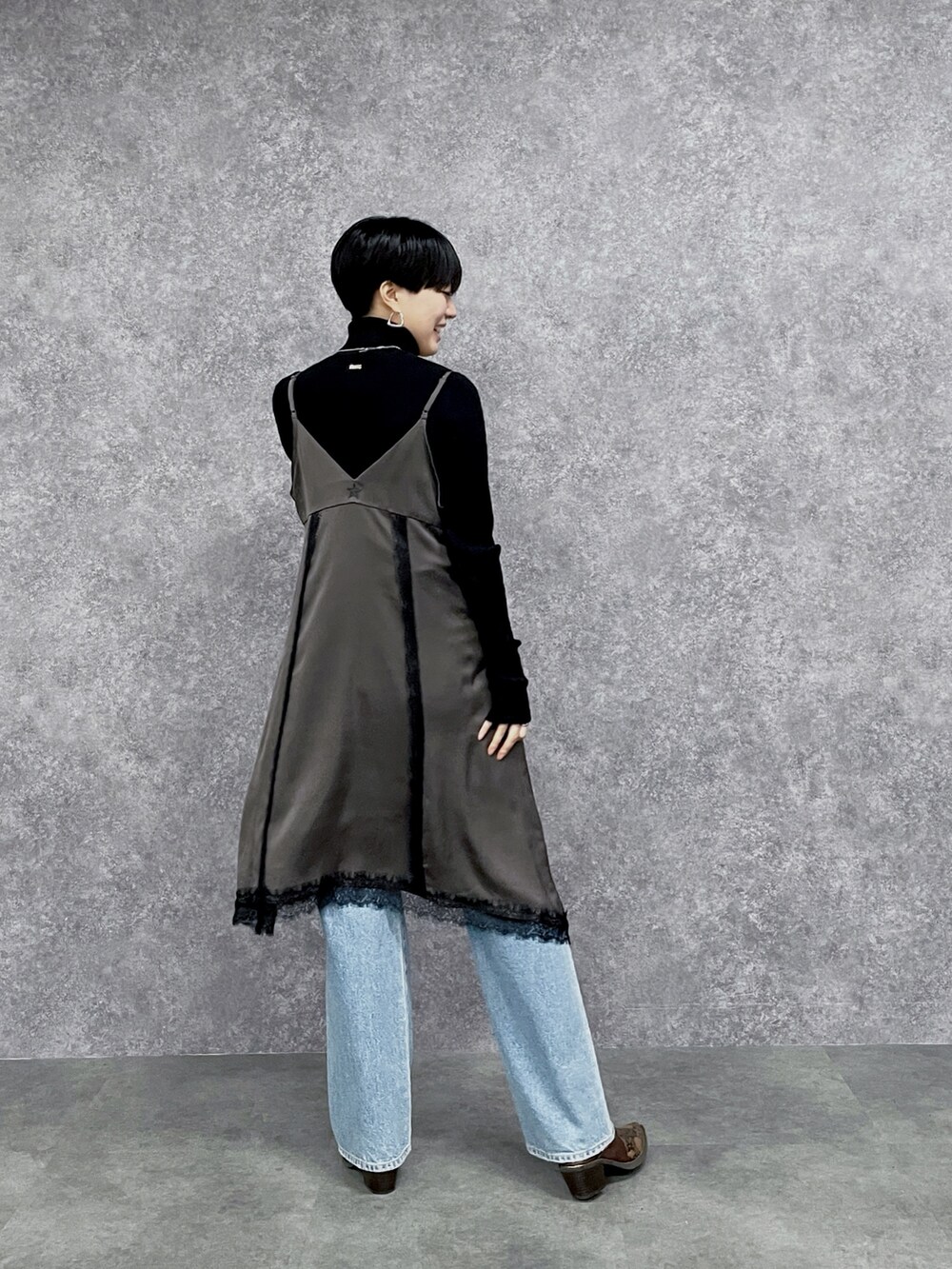 ブルー系のデニムパンツ、ブラック系のニット/セーター、ブラウン系のワンピースを着用したレディースの秋コーディネートの6枚目の写真