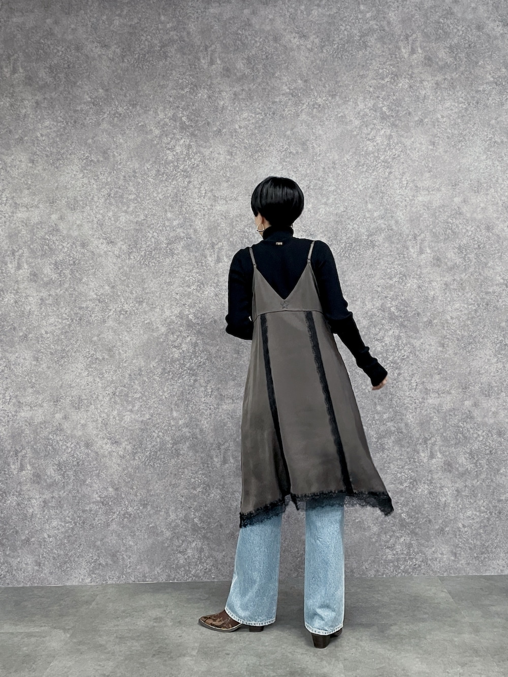 ブルー系のデニムパンツ、ブラック系のニット/セーター、ブラウン系のワンピースを着用したレディースの秋コーディネートの7枚目の写真