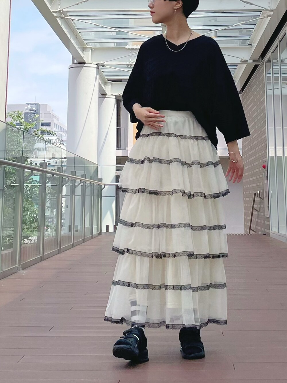 ホワイト系のスカート、ホワイト系のスカート、ブラック系のチュニックを着用したレディースの秋コーディネートの3枚目の写真