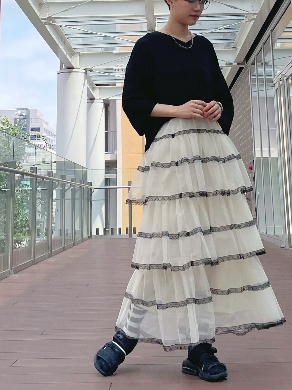 ホワイト系のスカート、ホワイト系のスカート、ブラック系のチュニックを着用したレディースの秋コーディネートの7枚目の写真